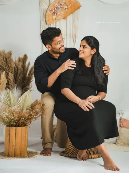 A happy couple enjoying their indoor maternity session. The boho decor provides a stylish and comfortable backdrop for their portraits.
