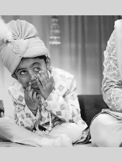 A young guest making funny faces during the ceremony. Capturing the antics of children adds a layer of charm and humor to your wedding album.