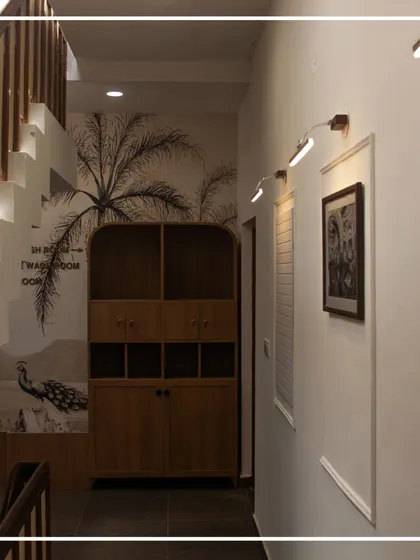 This view shows the interplay of elements in the stairwell passage. The heritage wallpaper, custom wooden cabinetry, and focused gallery lighting on the opposite wall create a balanced and thoughtfully composed corridor that is both a passage and a destination.