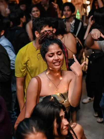 A woman with fairy lights, dancing and singing along. A magical, creative moment from the crowd.