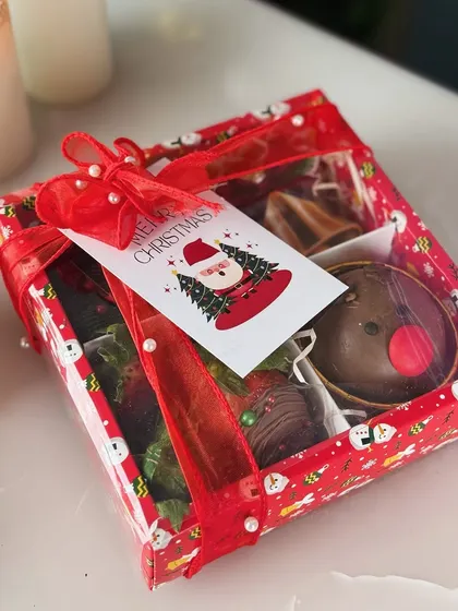 The fully packaged Christmas Treat Box, complete with a festive ribbon and a 'Merry Christmas' tag from Santa.