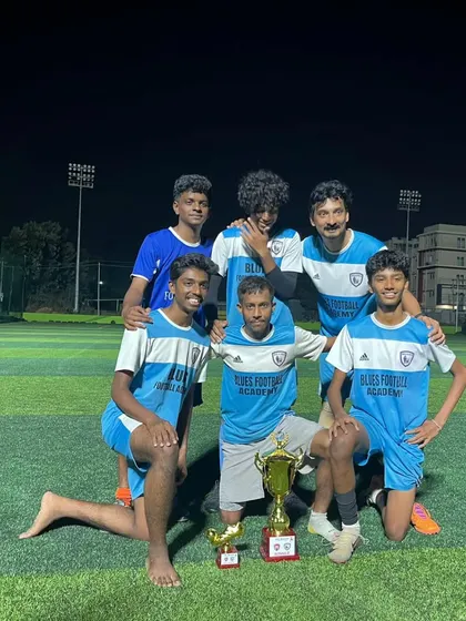 The C-Division squad celebrating their tournament victory under the floodlights. A testament to their hard work and team spirit.