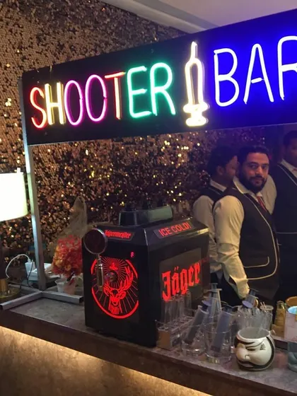 This setup includes our 'Shooter Bar' neon sign and a Jägermeister tap machine, perfect for a high-energy cocktail party or reception.