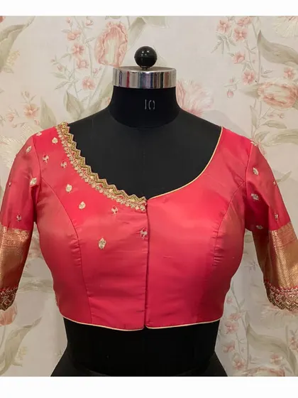 The front of the red blouse, featuring a simple neckline with delicate embroidery that complements the heavy work on the sleeves.