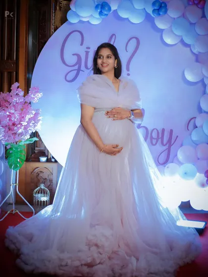 A client looking radiant at her baby shower in our light lavender tulle gown. The ruffled train and layered bodice create a beautiful silhouette.