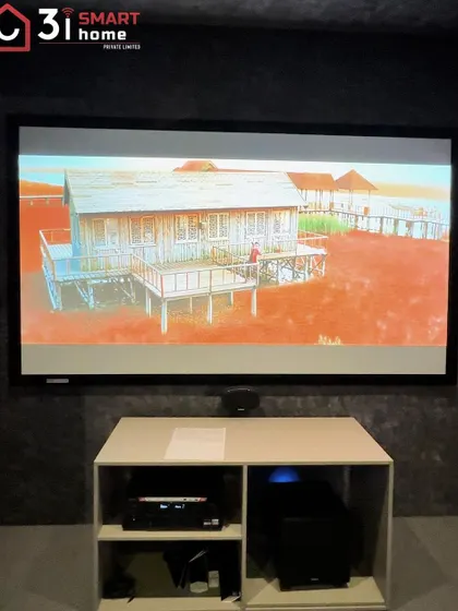 The front of the room in this compact cinema, with the AV equipment housed in a simple, open console below the screen.