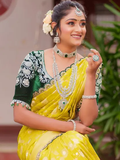 A smiling shot of the model wearing the green velvet blouse, showing how it can be styled for a grand occasion.