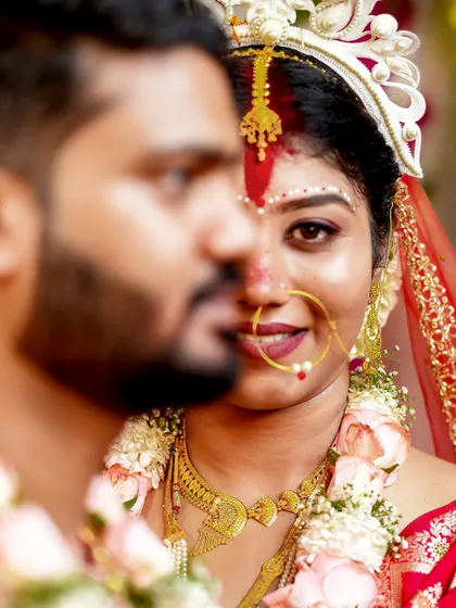 A beautiful close-up of a Bengali bride, showcasing the traditional sindoor and her serene smile.