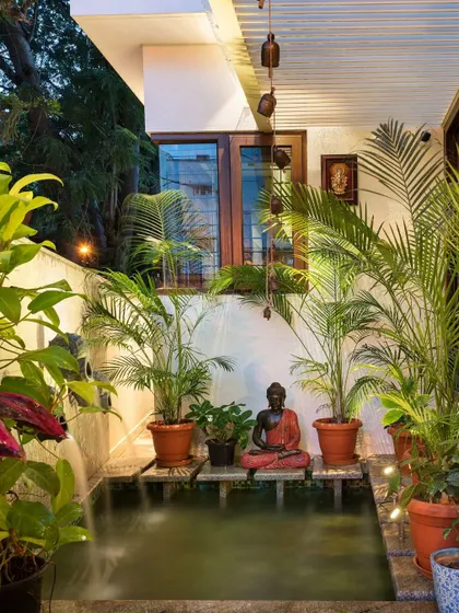 A small, tranquil water feature with a Buddha statue, nestled in a cozy corner of the patio. This detail adds a sensory element of sound and serenity to the outdoor experience.