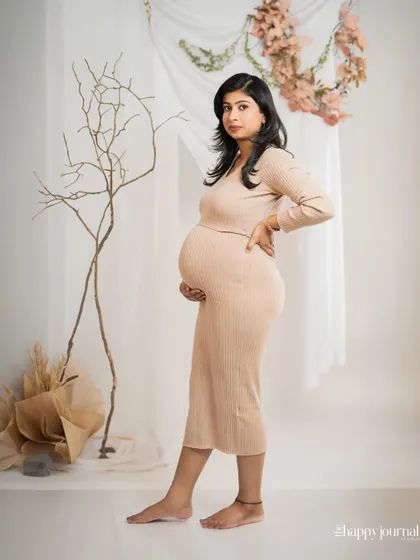 This side-profile portrait beautifully showcases the baby bump. The minimalist background with natural elements like pampas grass adds a touch of modern, bohemian style.