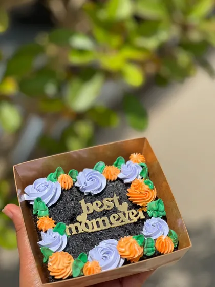A cute, floral-decorated mini brownie cake with a "best mom ever" topper. A sweet and personal gift for Mother's Day.