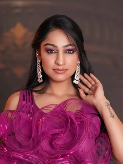 A glamorous reception look with dramatic purple eyeshadow and a modern ruffled gown.