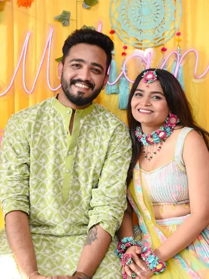 The happy couple together at their Mehendi ceremony, posing for a classic portrait.