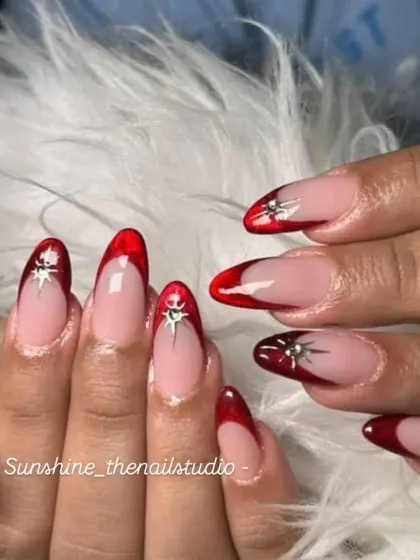 A bold and glossy look. This set features a deep red "jelly" French tip on a clear base, with a silver chrome star for a pop of detail.