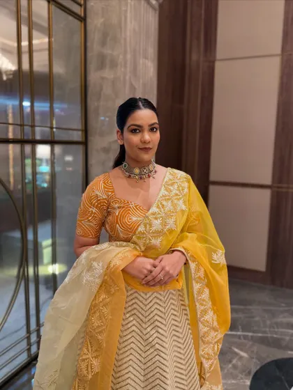 This front-facing shot shows the beautiful sweetheart neckline of the blouse and the delicate organza dupatta, which adds a layer of grace.