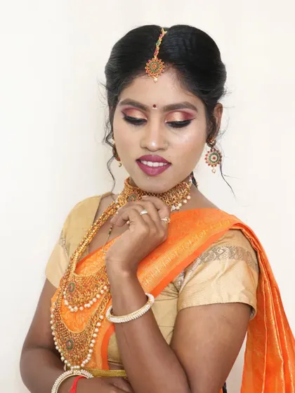 A close-up of this beautiful South Indian look. The eye makeup has shades of pink and gold, and the look is completed with a maang tikka and traditional jewelry.