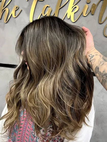 A signature ash blonde balayage, showing the process of foil work and the final, beautifully blended result.