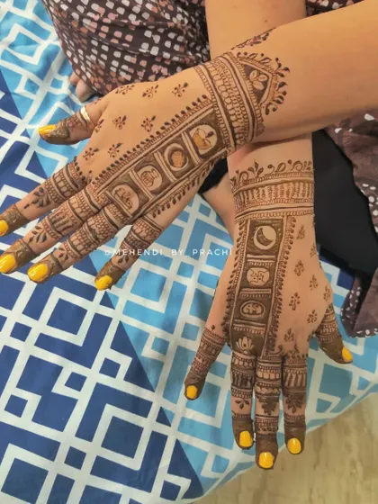 This design incorporates all the elements of the Karwa Chauth ritual in small, symbolic blocks along the fingers. It includes the moon, a sieve, and a pot, creating a unique and story-driven mehendi.
