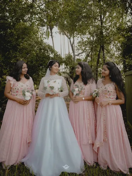 A bride shares a moment with her bridesmaids, all dressed in lovely pink gowns, showcasing the importance of friendship on the wedding day.