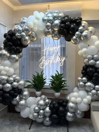 A chic black, white, and silver balloon ring with a neon sign, perfect for a modern home.