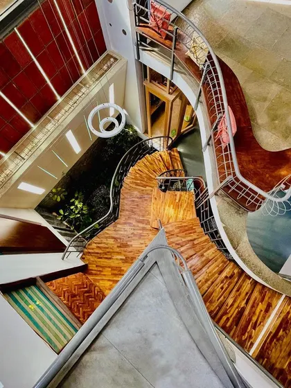 Don't walk, just flow. This top-down perspective of a staircase shows its organic, flowing geometry. The design encourages movement, guided by shifting light and the combination of wood, steel, and stone textures.