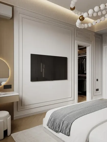 A modern bedroom with a walk-in closet. The design features a TV mounted on a paneled wall and a chic vanity area, blending functionality with high-end style.