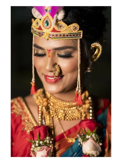 A close up portrait of the bride, her eyes closed in a moment of quiet happiness. Her traditional Maharashtrian jewelry and makeup are captured in beautiful detail.