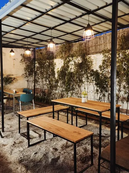 We transformed this simple cafe courtyard into a cozy, green oasis with bamboo screens, gravel flooring, and potted plants.