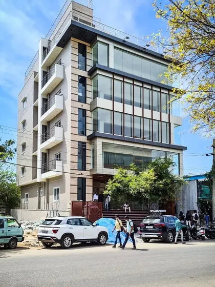A daytime photograph capturing the building's presence on a busy street, showing how the design interacts with the urban environment.