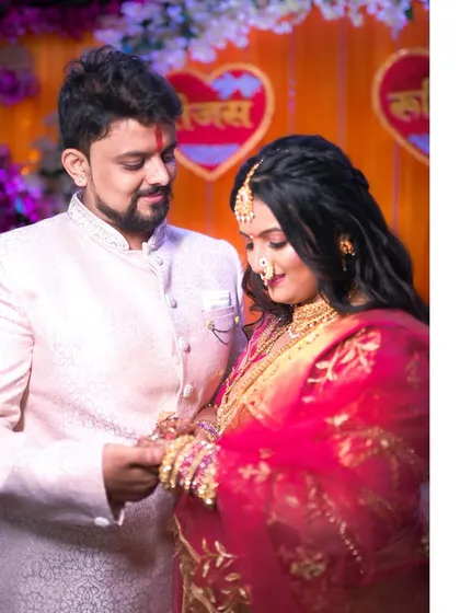 A side-by-side look at the ring exchange. This captures the couple's interaction and the intricate details of their traditional attire and the rings.
