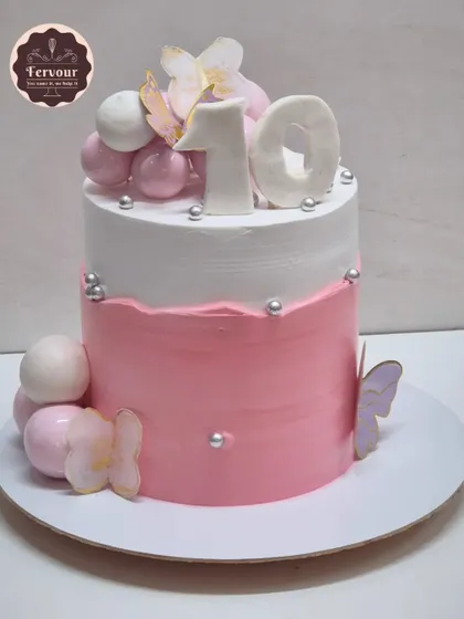 A pink and white ombre cake for a 10th birthday. This mocha chocolate cake is decorated with spheres and butterflies for a simple yet beautiful design.