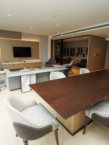 A view focusing on the dining area and its connection to the living room, perfect for showcasing hospitality and entertainment spaces in commercial property photography.