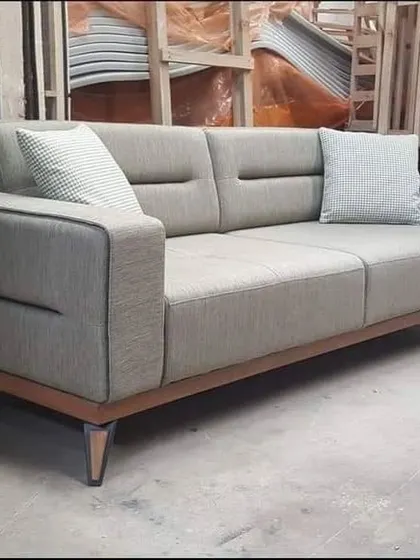A simple yet stylish three-seater sofa with a wooden base, showcasing the quality of my custom-made furniture right from the workshop.