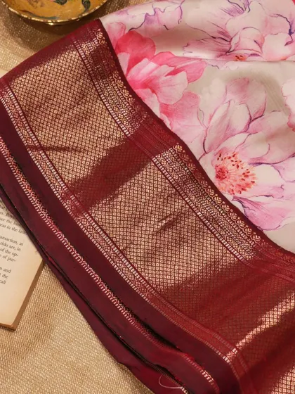 The contrast between the soft floral print and the heavy zari border makes this a unique piece for any celebration.