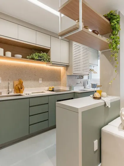 This design features a small peninsula that separates the kitchen from the living area without closing it off. The suspended wooden shelf adds storage and a unique design element.