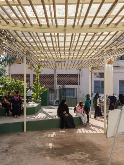 Women and children gather at the Basera Community Plaza. The design's openness and visibility from the street were crucial to making it an accessible and welcoming space for community discourse and grassroots activities.