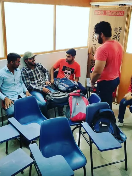 Learning happens best when you feel comfortable. This is a candid moment from one of our group discussions, where students are socializing and practicing their conversational English in a relaxed setting before a session begins.