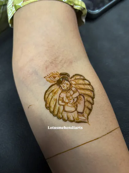 An adorable and simple motif of baby Krishna on a leaf, perfect as a standalone design or as part of a larger baby shower mehendi.