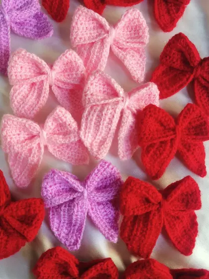 An array of our sailor bows in different shades of pink, purple, and red.
