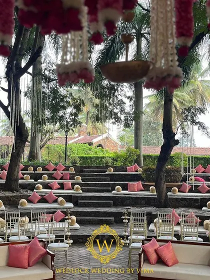 A glimpse into a stunning outdoor wedding we planned. The mandap was set in a courtyard amphitheater, with hanging floral tassels and elegant seating arrangements creating a romantic ambiance.