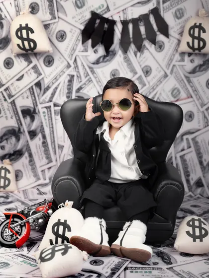 Adjusting his shades for the perfect power look. This little boss is all about style and attitude in this fun and creative money-themed shoot.