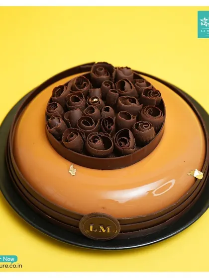 A top-down view of the chocolate rose cake, showing the beautiful mirror glaze finish and the detailed chocolate work in the center.