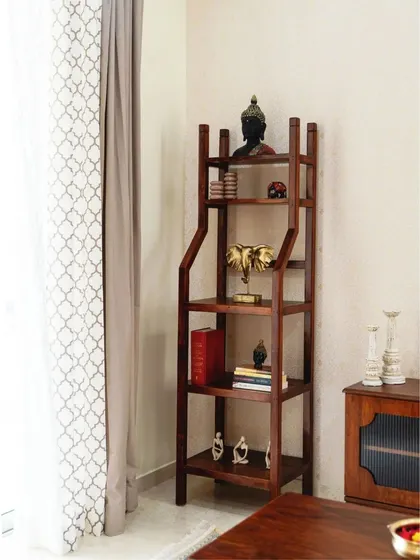 An étagère or ladder shelf used in a living room to display books and decorative items, adding height and personality to the corner.