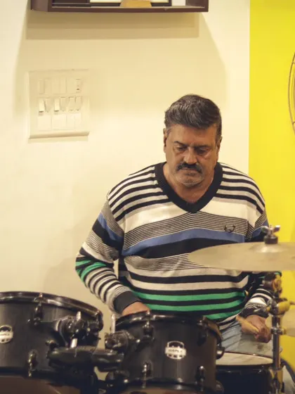 A seasoned musician on the drums during a jam session. Our community includes players of all ages and experience levels.