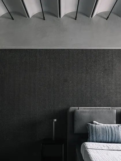 The guest room, a simple and clean space featuring a headboard made of Cubo granite and narrower ceiling vaults.