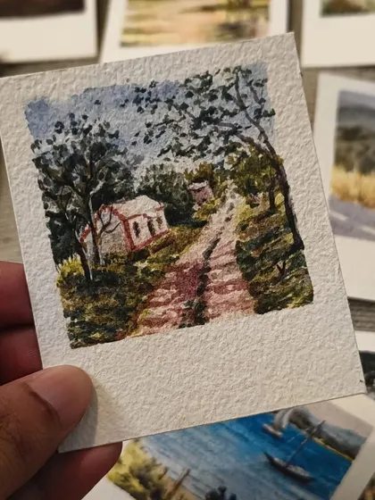 A winding path leads up to a small house in this charming, hand-painted scene. It’s a cozy and inviting piece of miniature art that tells a simple story.