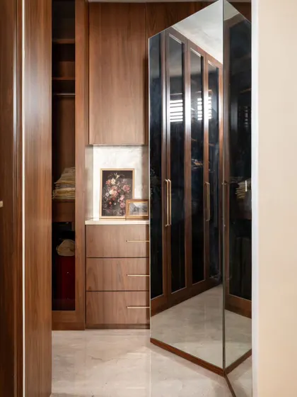 A clever use of mirrors can make a space feel larger and brighter. This full-length pivoting mirror in a walk-in closet is not only practical but also adds a dynamic and stylish element to the room.