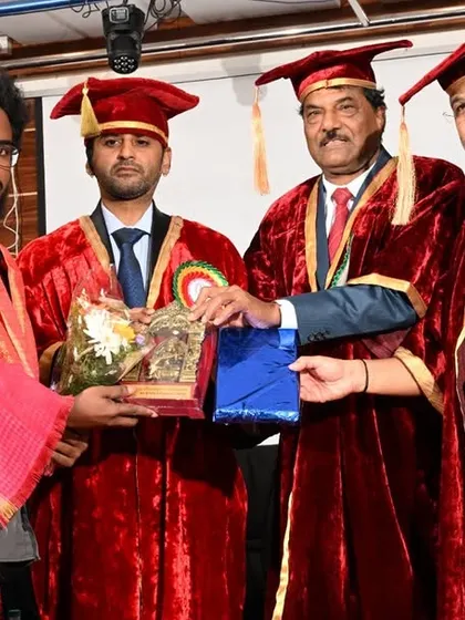 A collective moment of presenting an award, joined by other dignitaries on the stage.