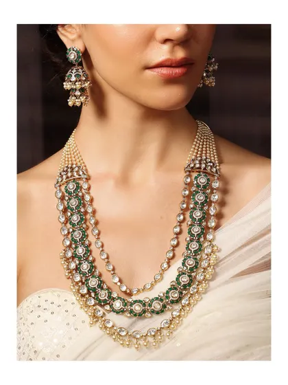 This multi-layered pearl and emerald necklace offers a classic and sophisticated bridal look, combining traditional elements with a fresh design.