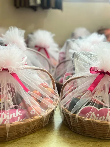 A side view of the 'Pink Lady' gift baskets, highlighting the fresh apples and branded items inside.